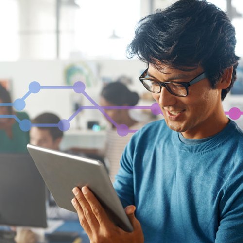 Image of man, with glasses, using a tablet. This is used to depict the benefits of Vonage Reports API.