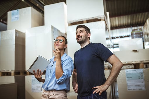 woman and man taking inventory in warehouse