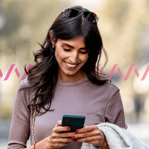 Photo of a woman looking at a mobile phone and smiling