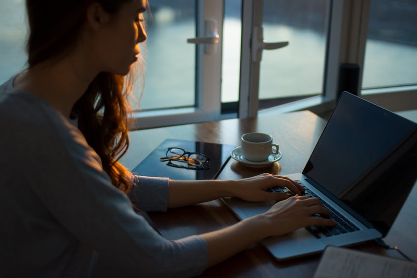 Side view of a woman working from home on her laptop