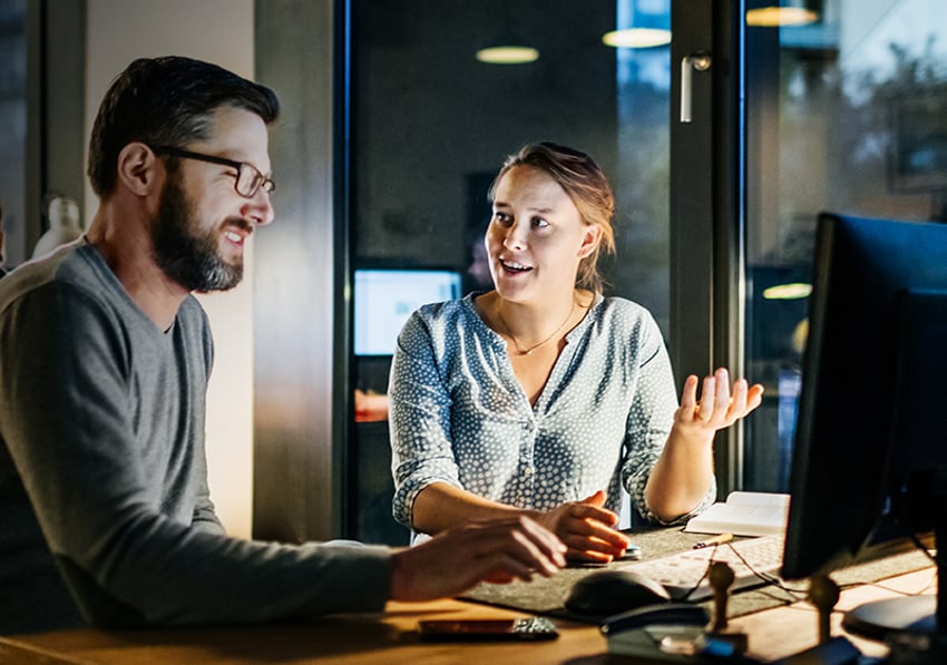 SMB collaboration (840px) man and woman sitting at a desk and talking in front of a computer screen