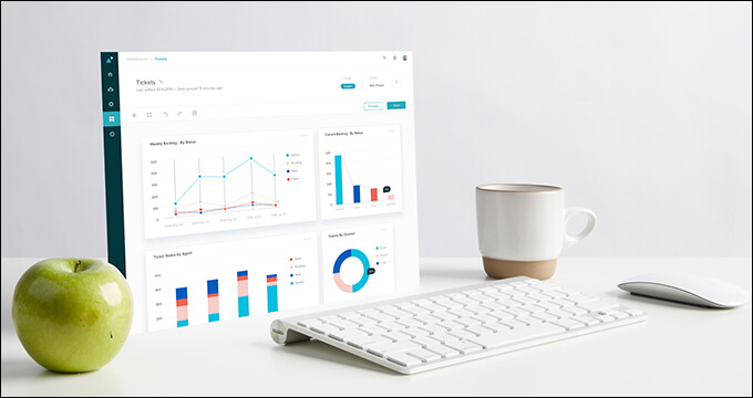 Picture of the Zendesk interface on a computer sitting on a desk with and apple and cup of coffee