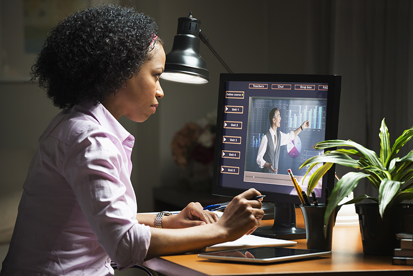 Student at desk computer looking at eLearning lesson on screen
